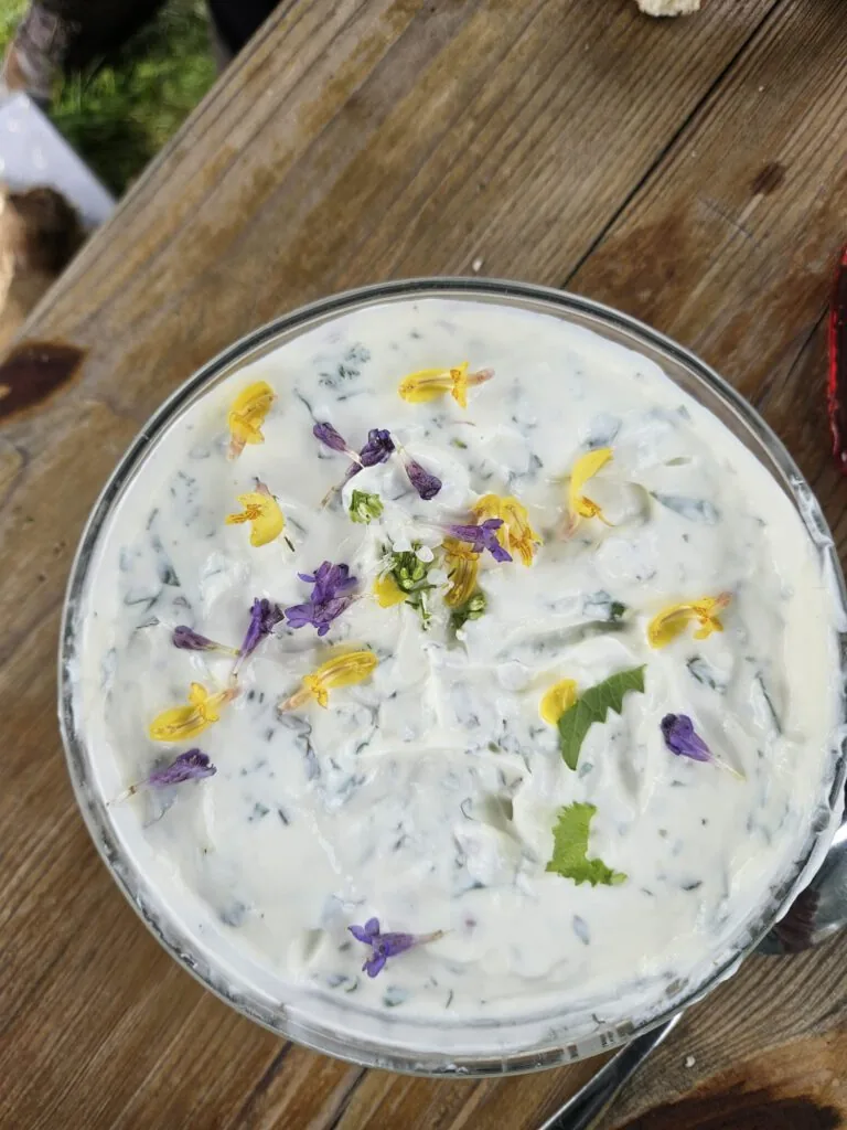 Schüssel mit Quark und Kräutern auf einem Holztisch